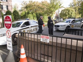 Officers with the Uniform Division of the United States Secret Service talk at a checkpoint near the home of President Barack Obama, Wednesday, Oct. 24, 2018, in Washington. The U.S. Secret Service says agents have intercepted packages containing "possible explosive devices" addressed to former President Barack Obama and Hillary Clinton.