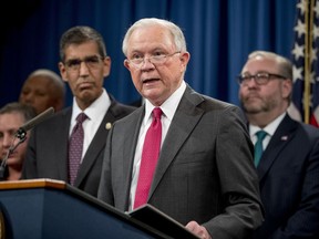 Attorney General Jeff Sessions, center, accompanied by Drug Enforcement Administration Acting Administrator Uttam Dhillon, center left, and other officials from the State Department, Treasury Department, Internal Revenue Service and Immigration and Customs Enforcement, speaks at a news conference to announce enforcement efforts against Cartel Jalisco Nueva Generacion, Tuesday, Oct. 16, 2018, at the Justice Department in Washington.