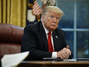 President Donald Trump listens to a question during an interview with The Associated Press in the Oval Office of the White House, Tuesday, Oct. 16, 2018, in Washington.
