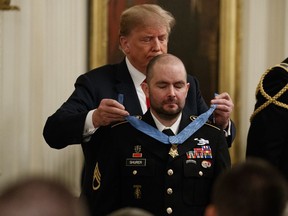 President Donald Trump presents the Congressional Medal of Honor to former Army Staff Sgt. Ronald J. Shurer II for actions in Afghanistan, in the East Room of the White House, Monday, Oct. 1, 2018, in Washington.