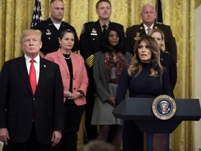 President Donald Trump listens as first lady Melania Trump speaks during an event on the opioid crisis, in the East Room of the White House, Wednesday, Oct. 24, 2018, in Washington.