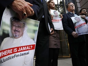 Alyssa Edling, center, and Thomas Malia, second from right, both with PEN America, join others as they hold signs of missing journalist Jamal Khashoggi, during a news conference about his disappearance in Saudi Arabia, Wednesday, Oct. 10, 2018, in front of The Washington Post in Washington.