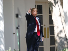 President Donald Trump gives a thumbs up to the media as he walks along the colonnade near the Rose Garden of the White House in Washington, Monday, Oct. 1, 2018.