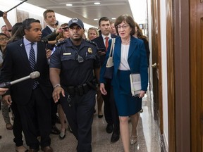 Sen. Susan Collins, R-Maine, is escorted by U.S. Capitol Police as she is met by cameras and reporters asking about embattled Supreme Court nominee Brett Kavanaugh, on Capitol Hill in Washington, Wednesday, Oct. 3, 2018. Collins was arriving to chair the Senate Special Committee on Aging.