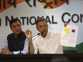 India's Congress party President Rahul Gandhi displays documents as he accuses Narendra Modi's government of buying 36 Rafale fighter jets from France's Dassault at a highly inflated price, in New Delhi, India, Thursday, Oct. 11, 2018. Gandhi also accused Modi's government of favoring the company owned by industrialist Anil Ambani, Reliance Group, when choosing an Indian partner for Dassault. India's defense minister is travelling to Paris amid controversy over the multi-billion dollar deal. (AP Photo)