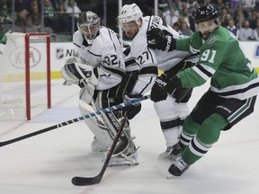 Los Angeles Kings goaltender Jonathan Quick passes the puck as defenseman Alec Martinez defends against Dallas Stars center Tyler Seguin, of Canada, in the first period of an NHL hockey game in Dallas Tuesday, Oct. 23, 2018.