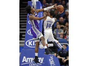 Sacramento Kings' De'Aaron Fox, left, blocks a shot attempt by Orlando Magic's D.J. Augustin (14) during the first half of an NBA basketball game, Tuesday, Oct. 30, 2018, in Orlando, Fla.