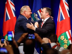Ontario Premier Doug Ford, left, and United Conservative Leader Jason Kenney embrace on stage at an anti-carbon tax rally in Calgary on Oct. 5, 2018.