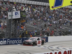 Christopher Bell takes the checkered flag to win the NASCAR Xfinity series auto race, Saturday, Oct. 6, 2018, at Dover International Speedway in Dover, Del.