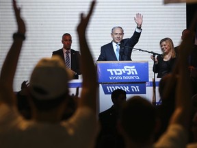 FILE - In this March 17, 2015 file photo, Israeli Prime Minister Benjamin Netanyahu greets supporters at the party's election headquarters in Tel Aviv, Israel. His top ministers are squabbling, a domestic political land mine beckons and an indictment for corruption could be just around the corner. Indications are mounting that Netanyahu may soon call for new elections, nearly a year ahead of schedule, bringing a premature end to his fourth term in office.