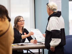 A poll worker gives a voter her ballot at a polling location in City Hall in London, Ont., on Monday, Oct. 22, 2018. London is the first municipality to adopt a ranked ballot system in Canada.