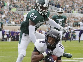 Northwestern's JJ Jefferson (12) catches a pass for a touchdown against Michigan State's Tre Person (24) during the second quarter of an NCAA college football game, Saturday, Oct. 6, 2018, in East Lansing, Mich.