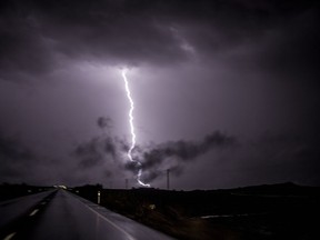 Lightning strikes ground on the outskirts of the village of Campillos, Spain, where heavy rain and floods caused much damage and the death of a firefighter according to Spanish authorities Sunday, Oct. 21 2018.  Emergency services for the southern region of Andalusia say that the firefighter went missing when his truck overturned on a flooded road during heavy rain that fell through the night, and his body was found after a search Sunday morning.