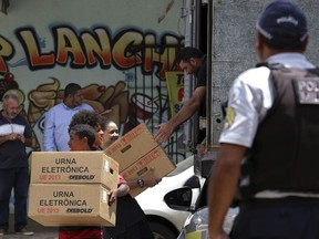 Regional Electoral Court employees deliver voting machines to a polling station at a public school, in Brasilia, Brazil, Friday, Oct. 5, 2018. Brazil's presidential election is set for Oct. 7.