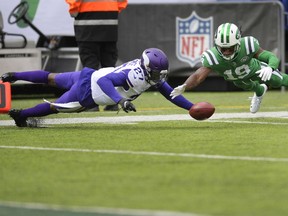 New York Jets wide receiver Andre Roberts (19) and Minnesota Vikings cornerback Xavier Rhodes (29) fight for control of the all after Roberts loses control of the ball on a punt return during the first half of an NFL football game Sunday, Oct. 21, 2018, in East Rutherford, N.J. Roberts recovered the ball on the play.