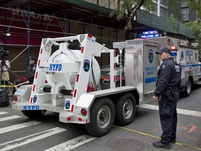 A police truck tows a total containment vessel to a post office in midtown Manhattan to dispose of a suspicious package, Friday, Oct. 26, 2018, in New York.