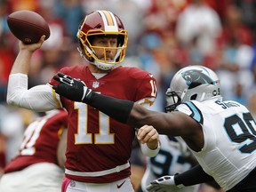Washington Redskins quarterback Alex Smith (11) passes the ball under pressure from Carolina Panthers defensive tackle Kawann Short (99) during the first half of an NFL football game, Sunday, Oct. 14, 2018, in Landover, Md.