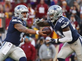 Dallas Cowboys quarterback Dak Prescott (4) hands off the ball to running back Ezekiel Elliott (21) during the first half of an NFL football game against the Washington Redskins, Sunday, Oct. 21, 2018 in Landover, Md.