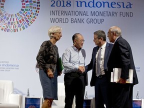 World Bank President Jim Yong Kim, second left, greets Director General of the World Trade Organization Roberto Azevedo, second right, Managing Director of International Monetary Fund (IMF) Christine Lagarde, left, and Secretary General of the Organization for Economic Co-operation and Development Angel Gurria during a trade conference in Bali, Indonesia Wednesday, Oct. 10, 2018.