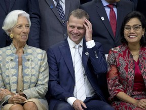 From left to right, Managing Director of International Monetary Fund (IMF) Christine Lagarde, Finland's Finance Minister Petteri Orpo, and Indonesia's Finance Minister Sri Mulyani Indrawati pose for a group photo during the IMF and World Bank meetings in Bali, Indonesia on Saturday, Oct. 13, 2018.