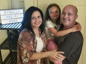 The Weir family, Vennita, left, Athena, center, and Bill take a photograph, at their home on Wednesday, September 27, 2018, in Albuquerque, N.M.  Military families are complaining that this year's base transfers are the worst in memory as movers are destroying, damaging, losing and stealing their household goods.