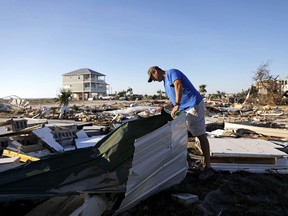 Mike Jackson sifts through debris looking for remnants of his home which was destroyed by hurricane Michael in Mexico Beach, Fla., Saturday, Oct. 13, 2018.