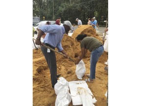 Tallahassee Mayor and Democratic gubernatorial candidate, Andrew Gillum, left, helps Eboni Sipling fill up sandbags in Tallahassee, Fla., Monday, Oct. 8, 2018. Residents in Florida's Panhandle and Big Bend are getting ready for Hurricane Michael, which is expected to make landfall by midweek.