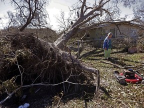 Mary Frances Parrish shows her toppled pecan tree, which fell in a neighbor's house, in the aftermath of Hurricane Michael in Panama City, Fla., Saturday, Oct. 13, 2018.  Parrish didn't leave the storm because her car was broken down, she didn't have a place to go and if she did she didn't have the money for it. She is caring for her terminally ill son who lives with her.
