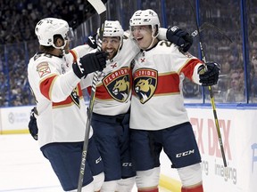 Florida Panthers left wing Mike Hoffman (68), center Vincent Trocheck (21) and defenseman Jacob MacDonald (23) celebrate MacDonald's goal during the first period of an NHL hockey game against the Tampa Bay Lightning Saturday, Oct. 6, 2018, in Tampa, Fla.