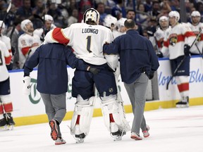 Florida Panthers goaltender Roberto Luongo (1) is helped to the bench after being injured during the second period of an NHL hockey game against the Tampa Bay Lightning Saturday, Oct. 6, 2018, in Tampa, Fla.