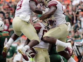 Florida State wide receiver Keith Gavin, center, celebrates with running back Jacques Patrick (9) and tight end Tre' McKitty, right, after scoring a touchdown during the first half of an NCAA college football game against Miami, Saturday, Oct. 6, 2018, in Miami Gardens, Fla.