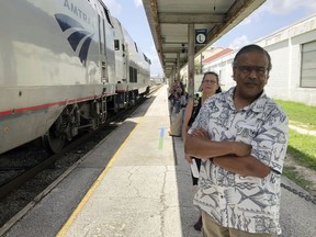In this Aug. 9, 2018 photo, Jishnu Mukdrji and Penny Jacobs wait to board an Amtrak train in Orlando, Fla. Murkdrji and Jacobs became friends from online train forums that get other rail enthusiasts together for trips around the United States. They were headed to Pennsylvania for a memorial service for one of the members in their train group who died of a heart attack in July while traveling with his train buddies to New Orleans.