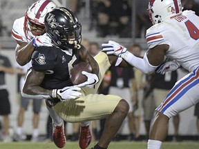 UCF wide receiver Dredrick Snelson (5) catches a pass in the end zone for a 14-yard touchdown between SMU defensive back Rodney Clemons, left, and safety Mikial Onu (4) during the first half of an NCAA college football game Saturday, Oct. 6, 2018, in Orlando, Fla.