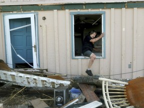 James Murphy emerges from what remains of his home on Thursday, Oct. 11, 2018, on a coastal stretch of Port St. Joe, Fla. The home was severely damaged by Hurricane Michael's violent storm surge and wind as it made landfall on Wednesday in the Florida Panhandle.