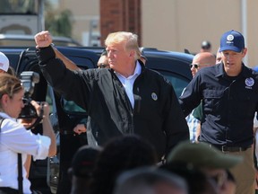 President Donald Trump raises his fist to chants of "USA" during a visit Monday, Oct. 15, 2018, to Lynn Haven, Fla., to see storm damage and recovery efforts following Hurricane Michael. Trump marveled at the roofless homes and uprooted trees he saw Monday while touring Florida Panhandle communities ravaged by the force of the hurricane.