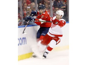 Florida Panthers defenseman Bogdan Kiselevich (55) and Detroit Red Wings defenseman Nick Jensen (3) battle for the puck during the first period of an NHL hockey game, Saturday, Oct. 20, 2018, in Sunrise, Fla.