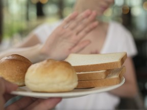 Gluten intolerance and diet concept. Woman refuses to eat white bread. Selective focus on bread