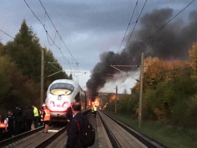 Flames and smoke rise over an ICE train near Montabaur, western Germany, Friday morning, Oct. 12, 2018. Nobody was injured when the high-speed train was evacuated.