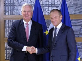 EU chief Brexit negotiator Michel Barnier, left, shakes hands for the media with European Council President Donald Tusk prior their talks at the European Council headquarters in Brussels, Tuesday, Oct. 16, 2018. Britain is set to leave the European Union in March, but a Brexit agreement must be sealed in coming weeks to leave enough time for relevant parliaments to ratify it.