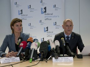 Federal Prosecutor Spokespersons Wenke Roggen, left, and Eric Van Duyse read a press release at the Belgium Federal Prosecutor Office in Brussels, Thursday, Oct. 11, 2018. Belgian authorities charged five people Thursday in relation to a massive financial fraud and match-fixing probe into soccer.