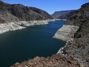 FILE - In this May 31, 2018, file photo, the low level of the water line is shown on the banks of the Colorado River in Hoover Dam, Ariz. Seven Southwestern U.S. states that depend on the overtaxed Colorado River say they have reached tentative agreements on managing the waterway amid an unprecedented drought. The plans announced Tuesday, Oct. 9 were a milestone for the river, which supports 40 million people and 6,300 square miles (16,300 square kilometers) of farmland in the U.S. and Mexico. The plans aren't designed to prevent a shortage, but they're intended to help manage and minimize the problems.