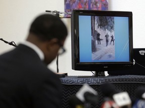 FILE - In this Jan. 18, 2016 file photo, attorney Adante D. Pointer, left, speaks at a news conference in San Francisco, as a video is displayed of the San Francisco police shooting of Mario Woods who police say appeared to raise a knife and approach one of the officers. A federal judge says video of the racially charged fatal San Francisco police shooting "casts doubt" on officers' accounts that Woods, a 26-year-old black man, was moving quickly toward them when they shot. The judge cited the videos Tuesday, Oct. 9, 2018, when he refused to toss out a wrongful death lawsuit filed by the victim's family against the officers. Five officers shot Woods a combined 21 times in December 2015. The shooting sparked weeks of protest over the department's treatment of minorities.