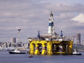 FILE - In this May 14, 2015 file photo, the oil drilling rig Polar Pioneer is towed toward a dock and in view of the Space Needle in Elliott Bay in Seattle. The first oil and gas production wells in federal Arctic waters have been approved by U.S. regulators. The Bureau of Ocean Energy Management on Wednesday, Oct. 24, 2018, announced it issued a conditional permit for the Liberty Project, a proposal by a subsidiary of Houston-based Hilcorp for production wells on an artificial island in the Beaufort Sea.