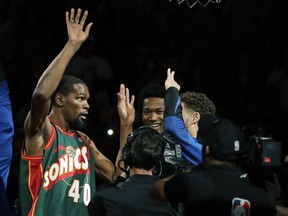 FILE - In this Oct. 5, 2018, file photo, Golden State Warriors forward Kevin Durant, left, appears during player introductions wearing the jersey of Seattle SuperSonics great Shawn Kemp as he greets teammates before an NBA basketball preseason game against the Sacramento Kings in Seattle. Durant played the final NBA game in KeyArena for the Seattle SuperSonics a decade earlier before the franchise's relocation to Oklahoma City, then returned for a nostalgic exhibition earlier this month in the venue's final event.