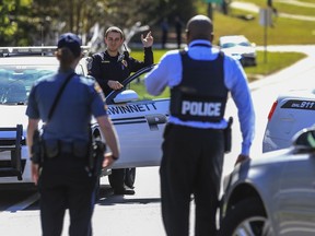 Gwinnett County police officers set up a perimeter around an area during a manhunt for Tafahree Maynard in Snellville, Ga., Monday, Oct. 22, 2018. A Gwinnett County police officer on Monday shot and killed Maynard, 18, accused of fatally shooting police officer Antwan Toney on Saturday near a school in the Atlanta area, police said.