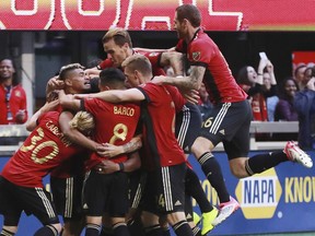 Atlanta United players mob Franco Escobar after his goal for a 1-0 lead over the Chicago Fire during the first half in a MLS soccer match on Sunday, Oct 21, 2018, in Atlanta.