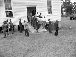 FILE- This July 25, 1946 file photo shows mourners as they carry the flag-draped coffin of lynching victim George W. Dorsey out of Mount Perry Baptist Church in Bishop, Ga. The brazen mass lynching horrified the nation that year but no one was ever indicted and investigations over the years failed to solve the case. More than 70 years after a grand jury failed to indict anyone in the lynching of two young black couples in rural Georgia, a historian is seeking the transcripts from the grand jury proceedings. A federal appeals court is set to hear arguments in the case Wednesday, Oct. 3, 2018. (The Atlanta Journal-Constitution via AP, File)