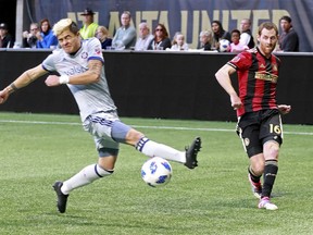 Atlanta United's Chris McCann, left, scores a goal past Chicago Fire midfielder Diego Campos during the first half of an MLS soccer match on Sunday, Oct. 21, 2018, in Atlanta.