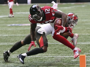 Atlanta Falcons wide receiver Mohamed Sanu (12) dives into the end zone past Tampa Bay Buccaneers safety Justin Evans during the first quarter of an NFL football game Sunday, Oct 14, 2018, in Atlanta.