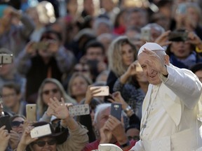 Pope Francis salutes the faithful as he arrives for his weekly general audience in St. Peter's Square at the Vatican, Wednesday, Oct. 24, 2018.